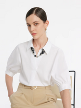 a lady in a white puff sleeves v-neck shirt with silk scarf